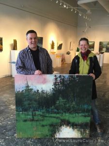 Artists Shane Norrie (L) and Laura Culic (R) with her painting in his gallery